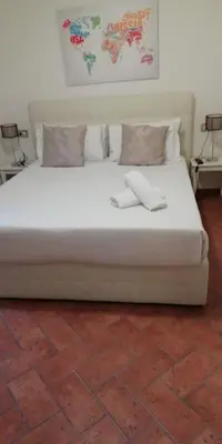 a white bed with two towels on top of it at Relais Arco Della Pace in Rome