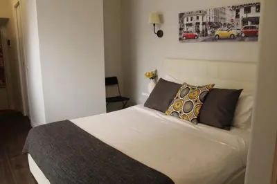 a bedroom with a white bed with pillows at Relais Arco Della Pace in Rome