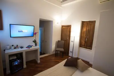 a living room with a tv on a wall at Relais Arco Della Pace in Rome
