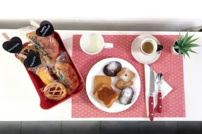 a table with a plate of pastries and a cup of coffee at Easy Apartment in Rome