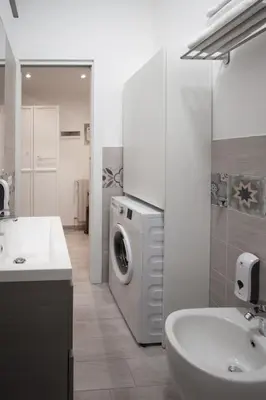 a bathroom with a washing machine and a sink at Easy Apartment in Rome