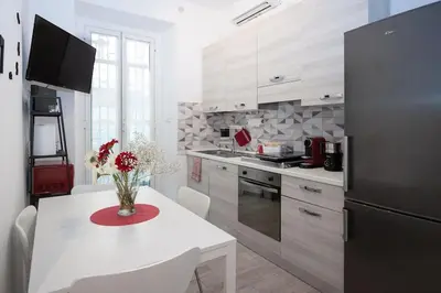 a kitchen with a white table and a black refrigerator at Easy Apartment in Rome