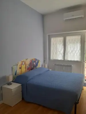 a bedroom with a blue bed and two windows at Casa con Giardino - Metro A Cornelia Vaticano a sole 4 fermate in Rome