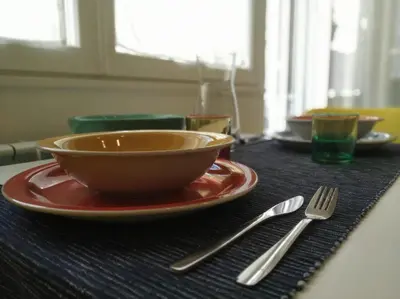 a table with a bowl and a plate and a fork at Casa con Giardino - Metro A Cornelia Vaticano a sole 4 fermate in Rome