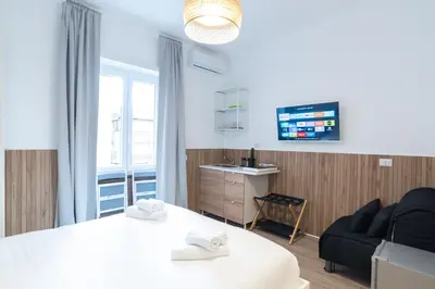 a room with a bed and a couch and a tv at Residence San Paolo in Rome