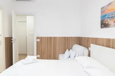 a bedroom with two white beds and a mirror at Residence San Paolo in Rome