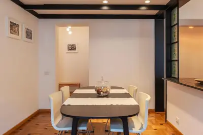 a dining room with a black table and white chairs at GuestHost - Trastevere Delightful Apartment in Rome