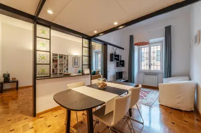 a dining room and living room with a table and chairs at GuestHost - Trastevere Delightful Apartment in Rome