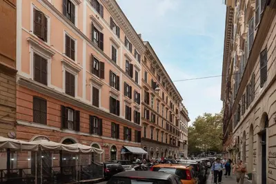 a street with cars parked next to tall buildings at GuestHost - Trastevere Delightful Apartment in Rome