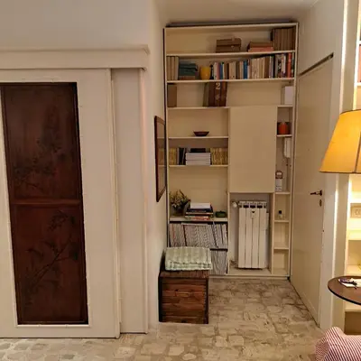a room with a door and a book shelf at HOUSE UP TO THE HILL - stanza con soggiorno a Monteverde vecchio in Rome