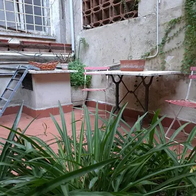 a table with plants in front of a building at HOUSE UP TO THE HILL - stanza con soggiorno a Monteverde vecchio in Rome