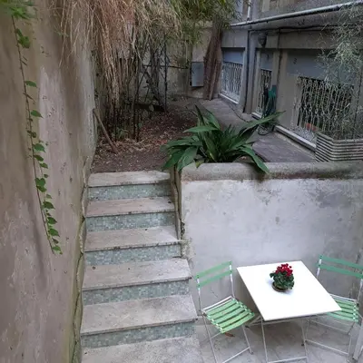 a table and two chairs and a table with flowers on it at HOUSE UP TO THE HILL - stanza con soggiorno a Monteverde vecchio in Rome