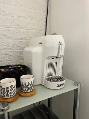 a coffee maker and two cups on a shelf at L’oasi di Trastevere in Rome
