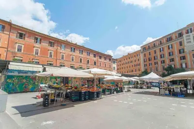 an outdoor market with tables and umbrellas in a city at L’oasi di Trastevere in Rome