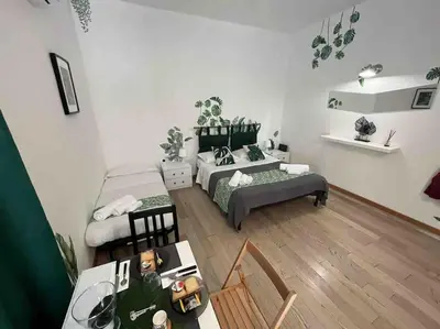 a living room with two beds and a table at L’oasi di Trastevere in Rome
