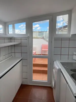 a kitchen with two windows and a view of a table at Piccolomini Design Apartment in Rome