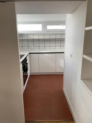 an empty kitchen with white cabinets and a window at Piccolomini Design Apartment in Rome