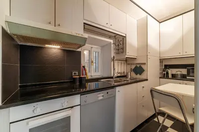 a kitchen with white cabinets and a stove top oven at GuestHost - Piazza di Spagna Classy Apartment in Rome
