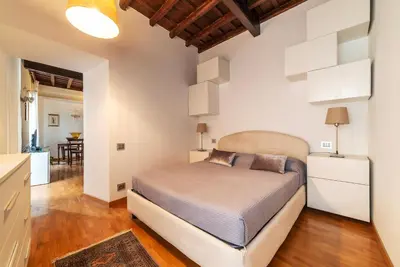 a bedroom with a large bed and a kitchen at GuestHost - Piazza di Spagna Classy Apartment in Rome