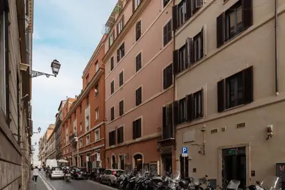 a row of motorcycles parked on a street next to buildings at GuestHost - Piazza di Spagna Classy Apartment in Rome