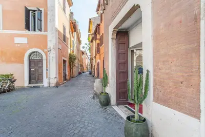 a cobblestone alley with cactuses in front of a building at L'antico borgo di Trastevere II in Rome