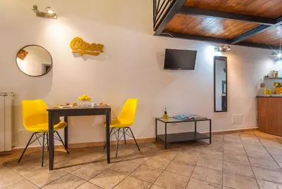 a living room with a table and yellow chairs at L'antico borgo di Trastevere II in Rome