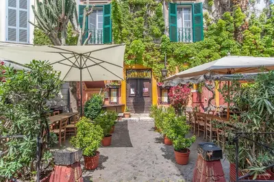 a patio with an umbrella and tables and chairs at L'antico borgo di Trastevere II in Rome
