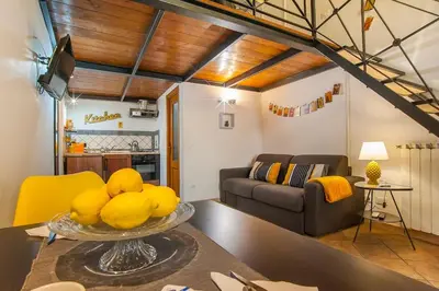 a living room with a table with a bowl of fruit at L'antico borgo di Trastevere II in Rome
