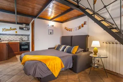 a bedroom with a large bed with a yellow blanket at L'antico borgo di Trastevere II in Rome
