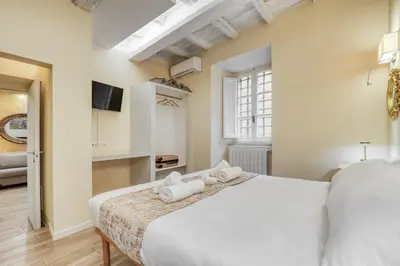 a bedroom with a large white bed and a window at Easybnb - Domus Orbitelli in Rome