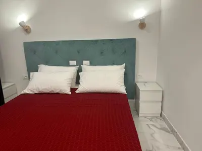 a bedroom with a red bed with a green headboard at Guesthouse Dahlia Rossa in Rome