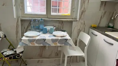 a small kitchen with a table with plates and water bottles at Guesthouse Dahlia Rossa in Rome