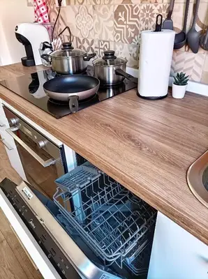 a dishwasher in a kitchen with a wooden counter top at Mamomi HOUSE in Rome