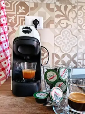 a coffee maker sitting on a table next to two cups at Mamomi HOUSE in Rome