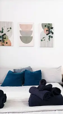 a bedroom with a bed with blue pillows and posters at Mamomi HOUSE in Rome