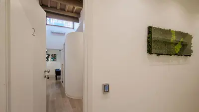 a white hallway with a painting on a wall at Ripetta Boutique Suites in Rome