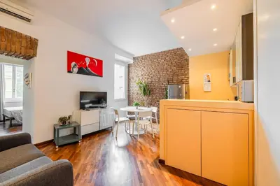 a kitchen and living room with a couch and a table at Piazza del Popolo Home 2 camere in Rome