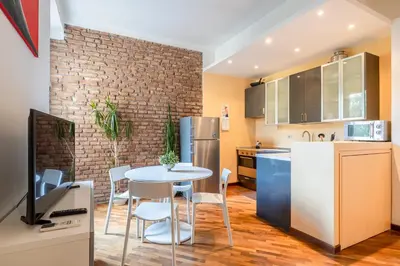 a kitchen with a table and chairs and a refrigerator at Piazza del Popolo Home 2 camere in Rome