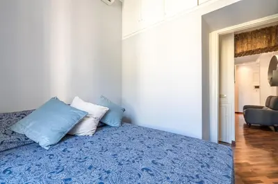 a bedroom with a blue bed with two pillows at Piazza del Popolo Home 2 camere in Rome