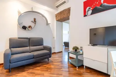 a living room with a chair and a flat screen tv at Piazza del Popolo Home 2 camere in Rome