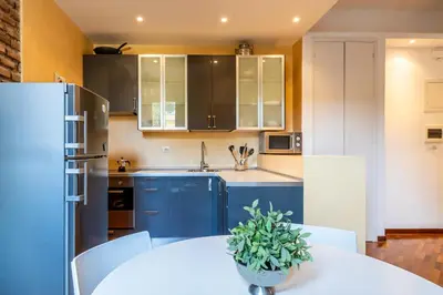 a kitchen with a white table and blue cabinets at Piazza del Popolo Home 2 camere in Rome
