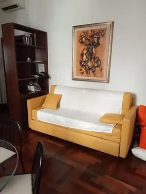 a yellow couch in a living room with a painting on the wall at Princess house Roma in Rome