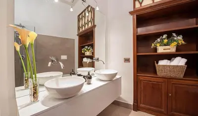 a bathroom with two sinks on a counter with flowers at Princess house Roma in Rome