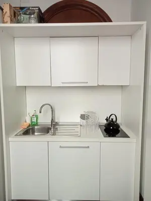 a kitchen with white cabinets and a sink at Princess house Roma in Rome