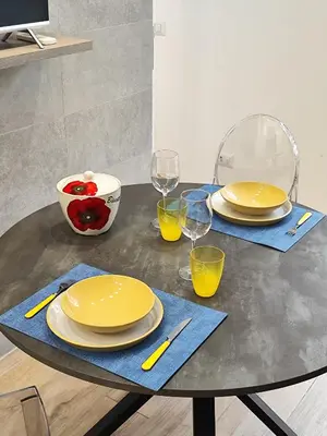 a table with yellow plates and wine glasses on it at Casa Aventino in Rome
