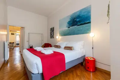 a bedroom with a large bed with a red blanket at Rome As You Feel - Two-Bedroom Apartment in Monti in Rome