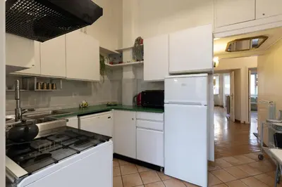 a kitchen with white cabinets and a white refrigerator at Rome As You Feel - Two-Bedroom Apartment in Monti in Rome
