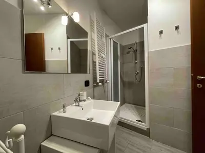a white bathroom with a sink and a shower at Spacious and Bright in Rome