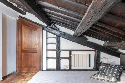 a bedroom with wooden ceilings and a wooden door at GuestHost - Cozy Trevi Romance in Rome
