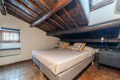 a bedroom with a bed and a wooden ceiling at GuestHost - Cozy Trevi Romance in Rome